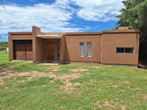 a small house on a grassy field in front at Casa Frente Dique Piedras Moras in Almafuerte +7 photos