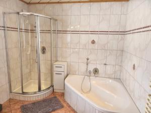 La salle de bains blanche est pourvue d'une baignoire et d'une douche. dans l'établissement Pension Wötzinghof, à Kirchberg in Tirol