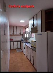 a kitchen with a white refrigerator in a room at Cobertura Parque das Aguas in Caldas Novas