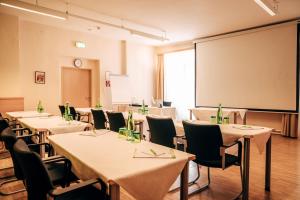 a conference room with tables and chairs and a large screen at Heilmoorbad Schwanberg in Schwanberg