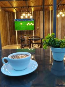 a cup of coffee on a table with a tv at Loca Pyramids View in Cairo