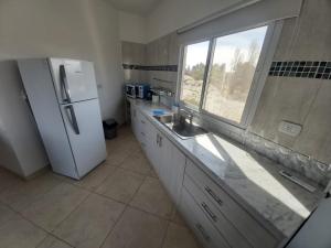a kitchen with a refrigerator and a window in it at Departamento en los Valles in Cafayate