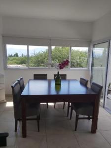 tavolo da pranzo con sedie e vaso con fiori di Departamento en los Valles a Cafayate