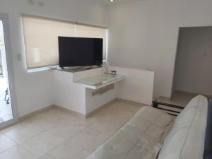 a living room with a couch and a flat screen tv at Departamento en los Valles in Cafayate