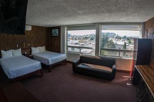 a hotel room with a bed and a couch and a window at Hotel Casablanca in Durango