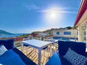 a balcony with a table and chairs and the ocean at Skyler Villaları in Kas