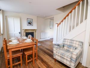 a dining room with a table and a chair at Railway Station Cottage in Llandrindod Wells