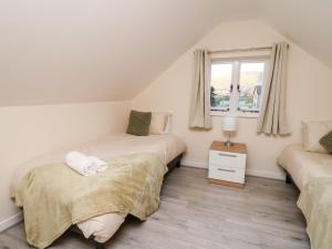 a bedroom with two beds and a window at Railway Station Cottage in Llandrindod Wells