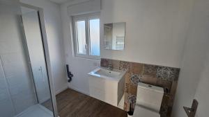uma casa de banho branca com um lavatório e um espelho em Nid douillet en Suisse Normande em Thury-Harcourt