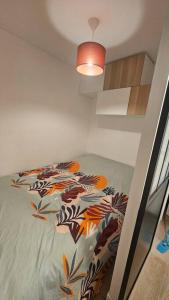 Nid douillet en Suisse Normande في Thury-Harcourt: غرفة نوم مع سرير مع لحاف ملون