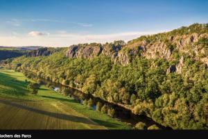 - une vue aérienne sur une rivière avec des arbres et des montagnes dans l'établissement Nid douillet en Suisse Normande, à Thury-Harcourt