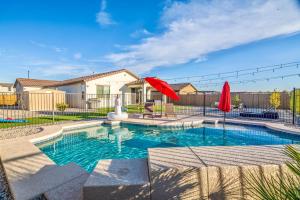 a swimming pool with a red umbrella and a house at Heated Pool King Bed Pool Table Ping Pong in Litchfield Park