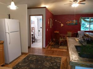 a kitchen with a refrigerator and a dining room at Aloha Crater Lodge in Volcano