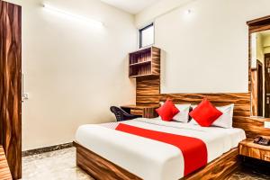 Habitación de hotel con cama con almohadas rojas en Eleven Suites en Kota