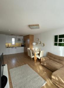 ein Wohnzimmer mit einem Sofa und einem Tisch in der Unterkunft Sarló Apartman in Debrecen