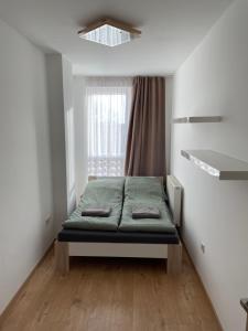 Bett in einem Zimmer mit Fenster in der Unterkunft Sarló Apartman in Debrecen