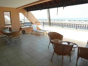 a balcony with chairs and a table and a table and chairs at Hotel Oceon in Caucaia