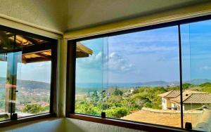 a room with a large window with a view of a house at Hotel Oceon in Caucaia