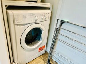 a washer and dryer sitting in a room at Cozy and Modern 1 Bed Apartment in Prime Location in Manchester