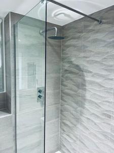 a shower with a glass door in a bathroom at Cozy and Modern 1 Bed Apartment in Prime Location in Manchester