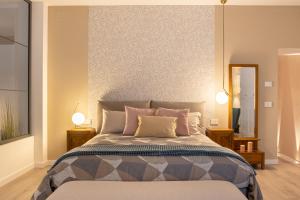 a bedroom with a large bed and a mirror at TRENTINO LODGE Piazza Municipio in Strigno +14 photos