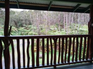 a view of a forest from a balcony at Aloha Crater Lodge in Volcano