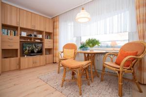 ein Esszimmer mit einem Tisch und Stühlen sowie einem TV in der Unterkunft Haus Ankerlicht 1.OG Wohnung 66 in Westerland