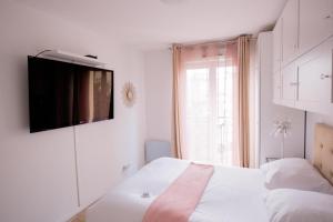 勒布爾熱的住宿－ELISE DE ROCHE Équipé Balcon Parking RER B，卧室配有一张床铺,墙上配有电视