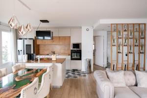 uma cozinha e sala de estar com um sofá e uma mesa em ELISE DE ROCHE Équipé Balcon Parking RER B em Le Bourget