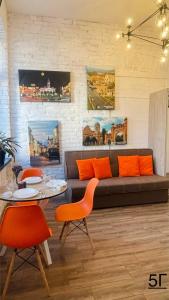 een woonkamer met een bank en een tafel en stoelen bij Квартира-студія в самому центрі міста біля Кобилянської in Tsjernivsi