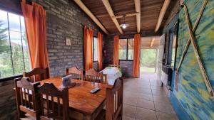 un comedor con una mesa de madera y una cama en Cabañas La Ofelia, en Potrerillos 36 fotos más