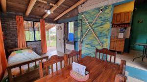 una habitación con una mesa y un comedor con una pintura en la pared en Cabañas La Ofelia, en Potrerillos