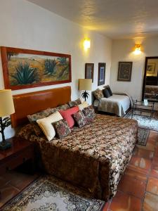 una camera d'albergo con un letto e due letti di Casa Tlaquepaque a Guadalajara