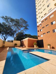 a swimming pool in front of a building at Edifício Belluno in Ribeirão Preto