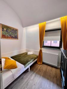 um quarto com uma cama e uma janela com cortinas amarelas em IRIS Le Dome Apartment em Timisoara