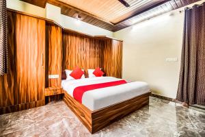 a bedroom with a bed with red pillows at Eleven Suites in Kota