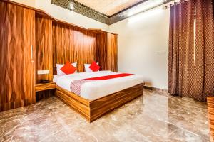 1 dormitorio con 1 cama con almohadas rojas en Eleven Suites en Kota