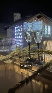 two wine glasses sitting on top of a table at A Frame house Kryvorivnia in Verkhniy Yasenov