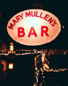 una señal para un bar de mulas de mono por la noche en Mary Mullen's Rooms Eyre Square. en Galway