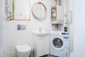 biała łazienka z pralką i umywalką w obiekcie Torun Bridge Apartament w Toruniu