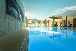 a large swimming pool with blue water in a building at Heilmoorbad Schwanberg in Schwanberg