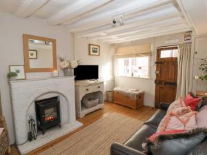 a living room with a fireplace and a television at Rosemary Cottage, Aldeburgh in Aldeburgh