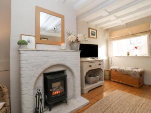 a living room with a fireplace and a mirror at Rosemary Cottage, Aldeburgh in Aldeburgh