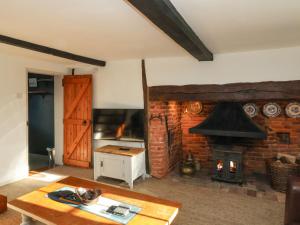 a living room with a fireplace and a stove at 2 Greensleeves in Saxmundham