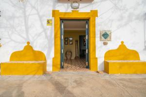 a yellow door to a building with a doorway at XPCE Casería San José in Bobadilla
