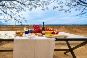 a table with a bottle of wine and food on it at XPCE Casería San José in Bobadilla