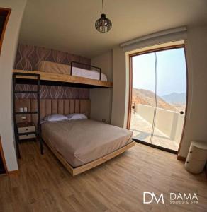 a bedroom with a bunk bed and a large window at Casa Dama in Cieneguilla