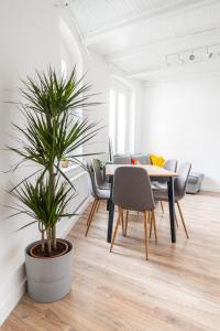 een eetkamer met een tafel en een potplant bij Torun Bridge Apartament in Toruń