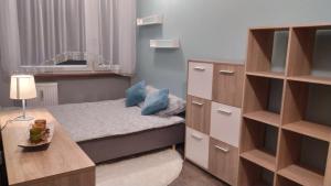 Habitación pequeña con cama y escritorio. en APARTAMENT SŁUPSK, en Słupsk