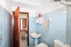 Baño azul con lavabo y aseo en Casa Jaya Taormina en Schisò